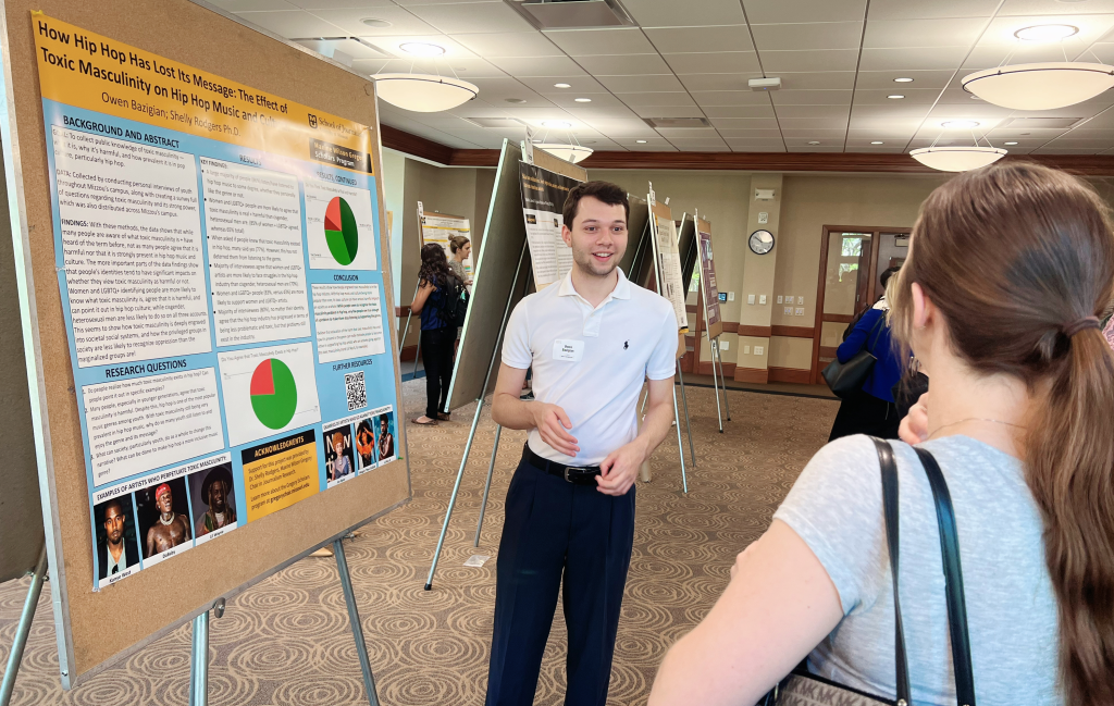 Photo of Owen Bazigian with his research poster at the 2023 Spring Research Forum.