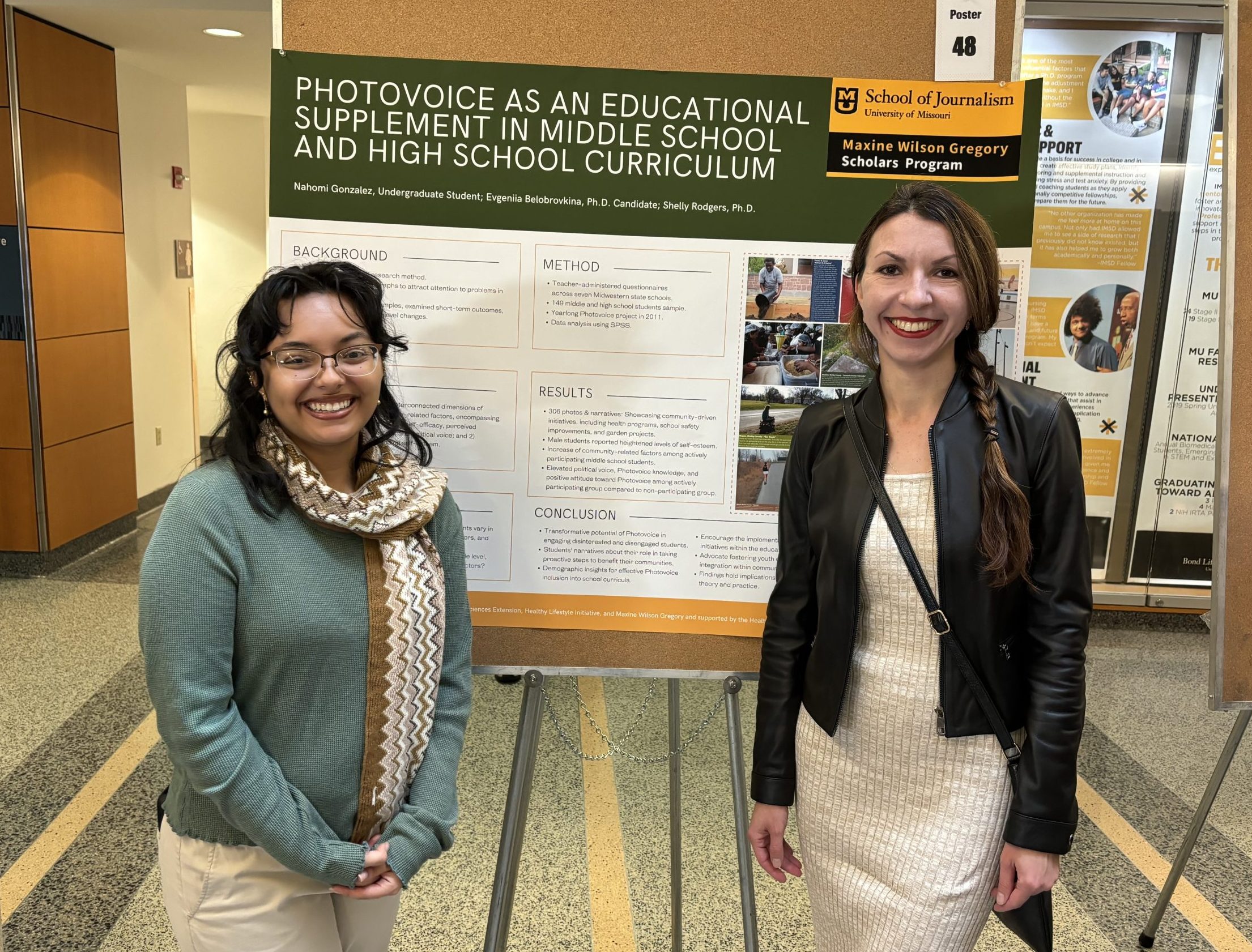Photo of Nahomi Gonzalez (left) and Evgeniia Belobrovkina with their research poster at the 2023 Fall Research Day.